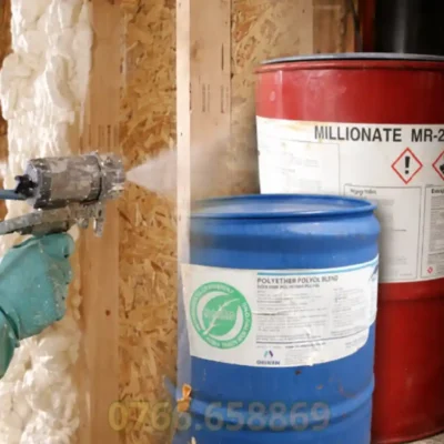 Hình ảnh thợ thi công phun foam PU cách nhiệt bằng thiết bị chuyên dụng, lớp foam nở đều bám kín bề mặt công trình