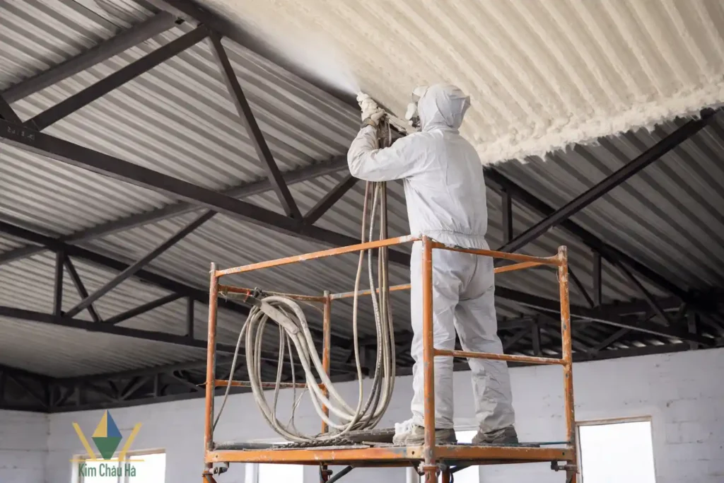 Công nhân phun PU Foam cách nhiệt mái tôn nhà công nghiệp trên giàn giáo an toàn